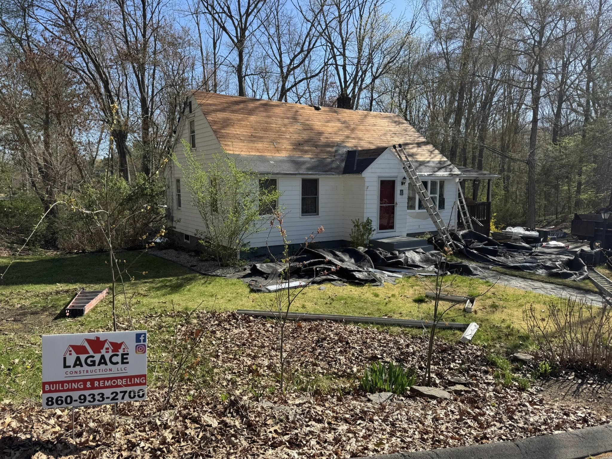 Lagace Construction replacing roof on white home in Andover, CT with visible branding sign and stripped shingles